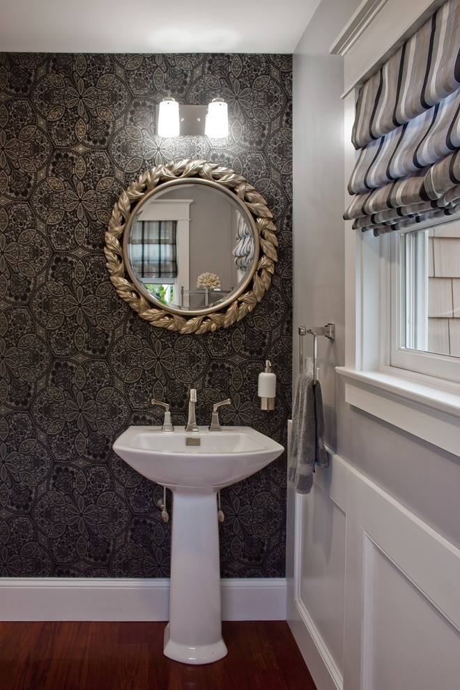 Foto på ett mellanstort funkis toalett, med ett piedestal handfat, grå väggar, mellanmörkt trägolv och brunt golv