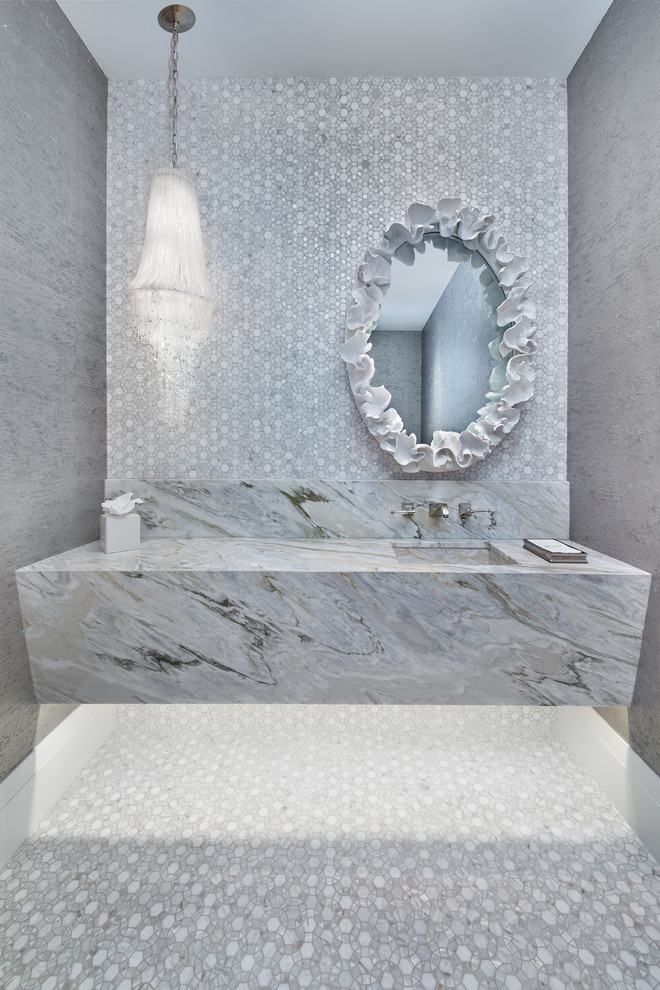 Example of a beach style gray tile gray floor powder room design in Miami with gray walls, an integrated sink and gray countertops