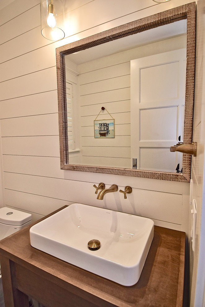 Kleine Maritime Gästetoilette mit offenen Schränken, hellbraunen Holzschränken, Toilette mit Aufsatzspülkasten, weißer Wandfarbe, Betonboden, Aufsatzwaschbecken, Waschtisch aus Holz und blauem Boden in Tampa