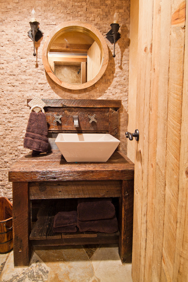 Diseño de aseo rural con lavabo sobreencimera, armarios abiertos, puertas de armario de madera en tonos medios, encimera de madera, baldosas y/o azulejos beige y encimeras marrones