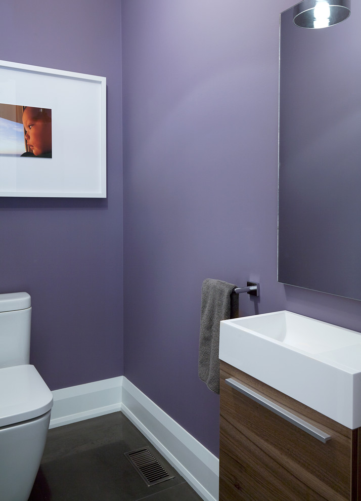 Photo of a small traditional cloakroom in Toronto with flat-panel cabinets, medium wood cabinets, a two-piece toilet, black tiles, grey tiles, purple walls and porcelain flooring.