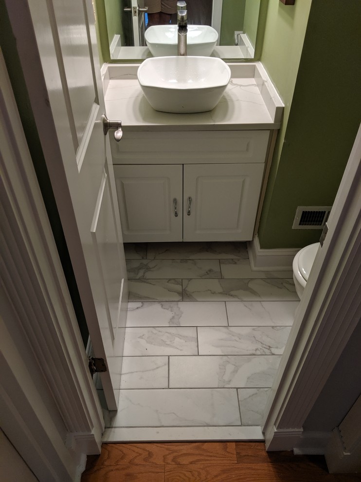 Réalisation d'un petit WC et toilettes tradition avec un placard avec porte à panneau surélevé, des portes de placard blanches, un mur vert, un sol en marbre, une vasque, un plan de toilette en quartz, un sol gris et un plan de toilette gris.