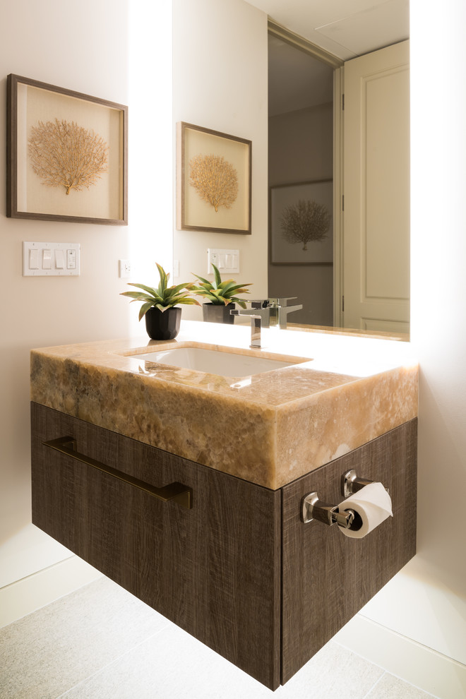 Esempio di un piccolo bagno di servizio moderno con ante lisce, ante in legno scuro, WC monopezzo, pavimento in gres porcellanato, lavabo sottopiano, top in onice, pavimento grigio e top beige