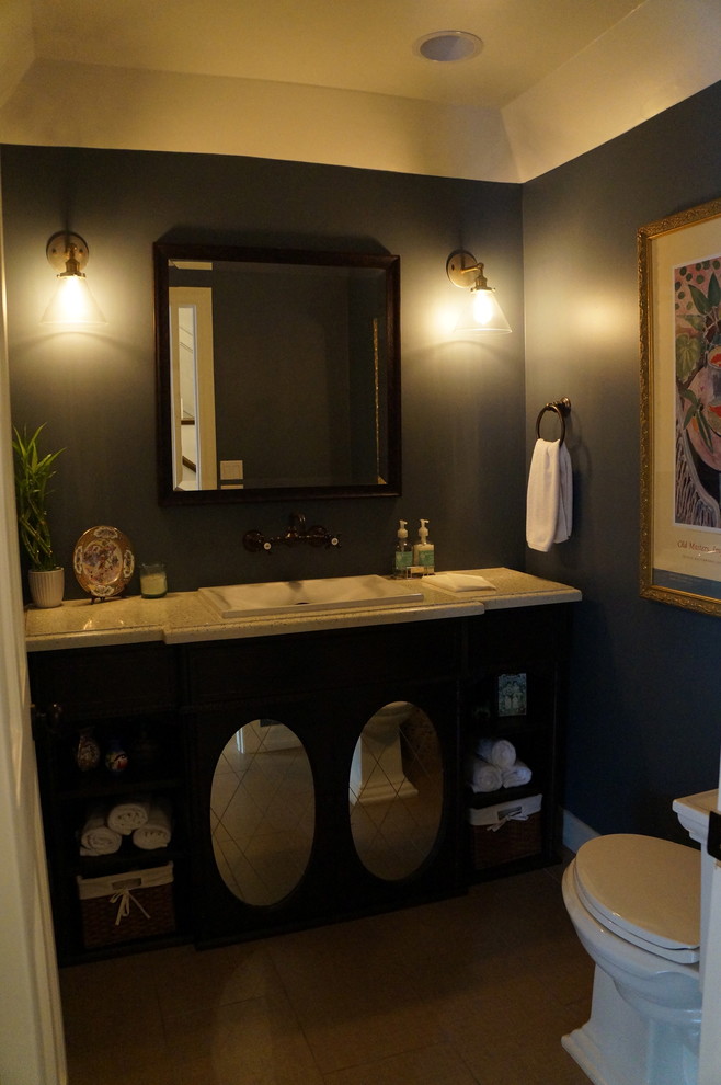 Bild på ett vintage toalett, med möbel-liknande, skåp i mörkt trä, bänkskiva i återvunnet glas, en toalettstol med separat cisternkåpa, klinkergolv i porslin och blå väggar