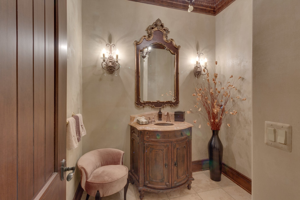 Foto på ett mellanstort vintage toalett, med möbel-liknande, skåp i mellenmörkt trä, beige kakel, klinkergolv i keramik, ett undermonterad handfat, marmorbänkskiva, beige väggar och beiget golv