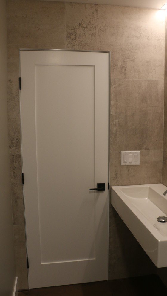 Diseño de aseo actual pequeño con paredes grises, lavabo integrado, suelo de madera en tonos medios y suelo marrón