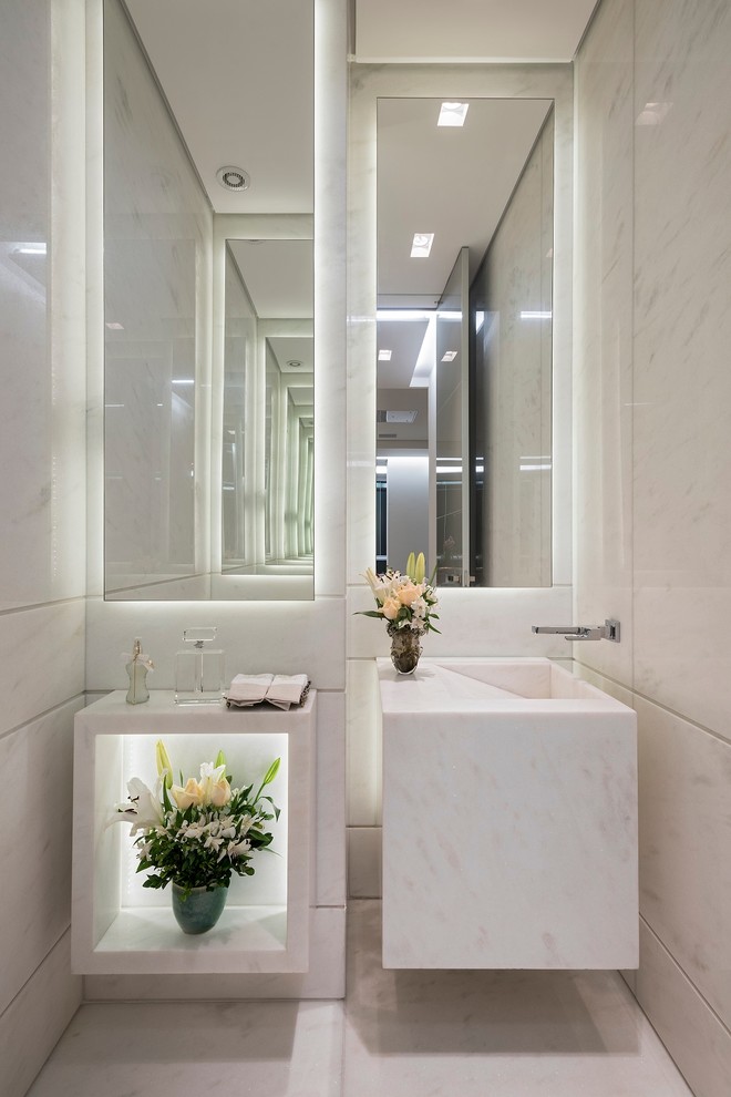 Foto di un piccolo bagno di servizio contemporaneo con nessun'anta, lastra di pietra, pareti bianche, lavabo integrato e pavimento bianco