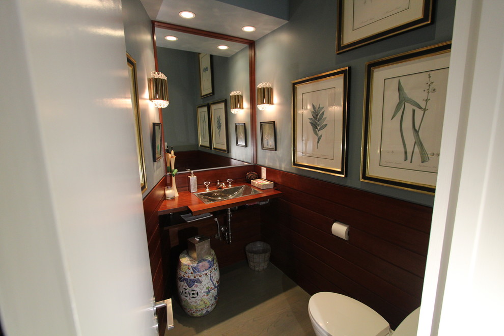 Kleine Maritime Gästetoilette mit Wandtoilette mit Spülkasten, blauer Wandfarbe, braunem Holzboden, Einbauwaschbecken, Waschtisch aus Holz und braunem Boden in Los Angeles