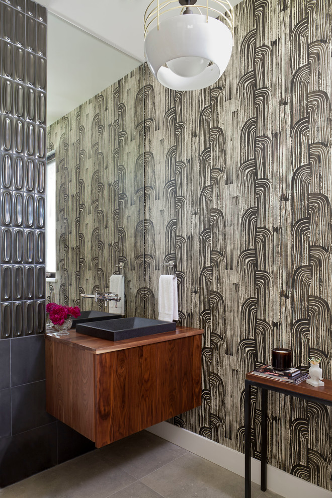 Foto di un bagno di servizio minimal con ante lisce, ante in legno bruno, piastrelle grigie, pareti multicolore e top in legno