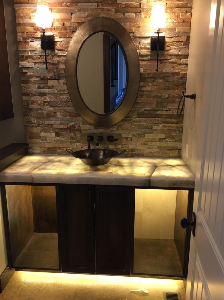 This is an example of a small traditional cloakroom in Other with flat-panel cabinets, black cabinets, red tiles, stone tiles, beige walls, travertine flooring, a vessel sink, onyx worktops and beige floors.