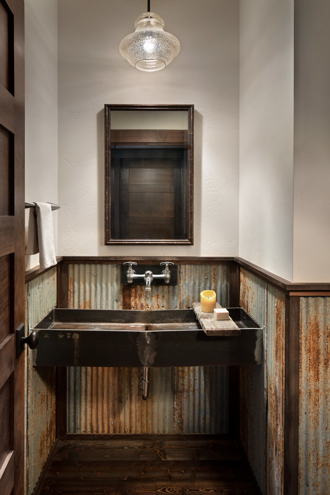 Urige Gästetoilette mit Metallfliesen, weißer Wandfarbe, Trogwaschbecken, dunklem Holzboden und braunem Boden in Sonstige