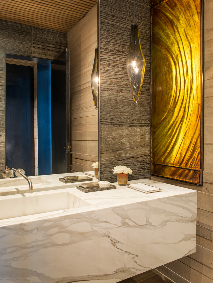 Imagen de aseo rústico con paredes marrones, lavabo integrado, encimera de mármol y encimeras blancas