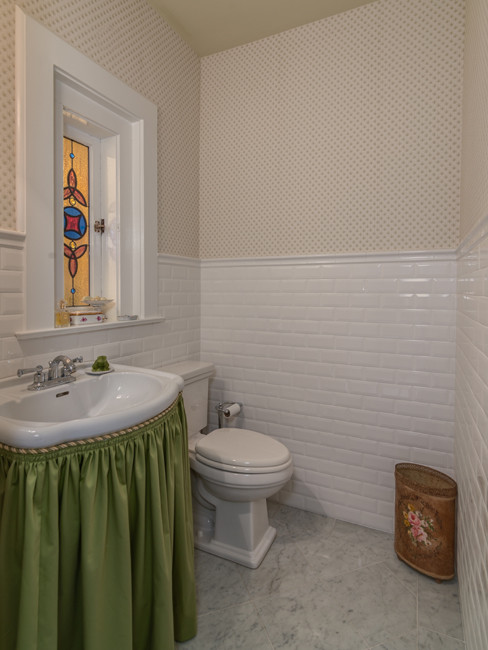 Foto di un bagno di servizio classico di medie dimensioni con lavabo a colonna, ante bianche, WC monopezzo, piastrelle bianche, piastrelle in ceramica, pareti beige e pavimento con piastrelle in ceramica