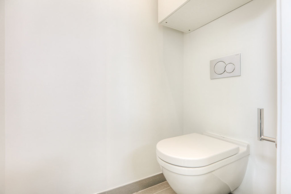 Идея дизайна: туалет среднего размера в стиле модернизм с плоскими фасадами, белыми фасадами, плиткой мозаикой, белыми стенами, столешницей из искусственного камня, инсталляцией, разноцветной плиткой, полом из травертина, настольной раковиной и бежевым полом