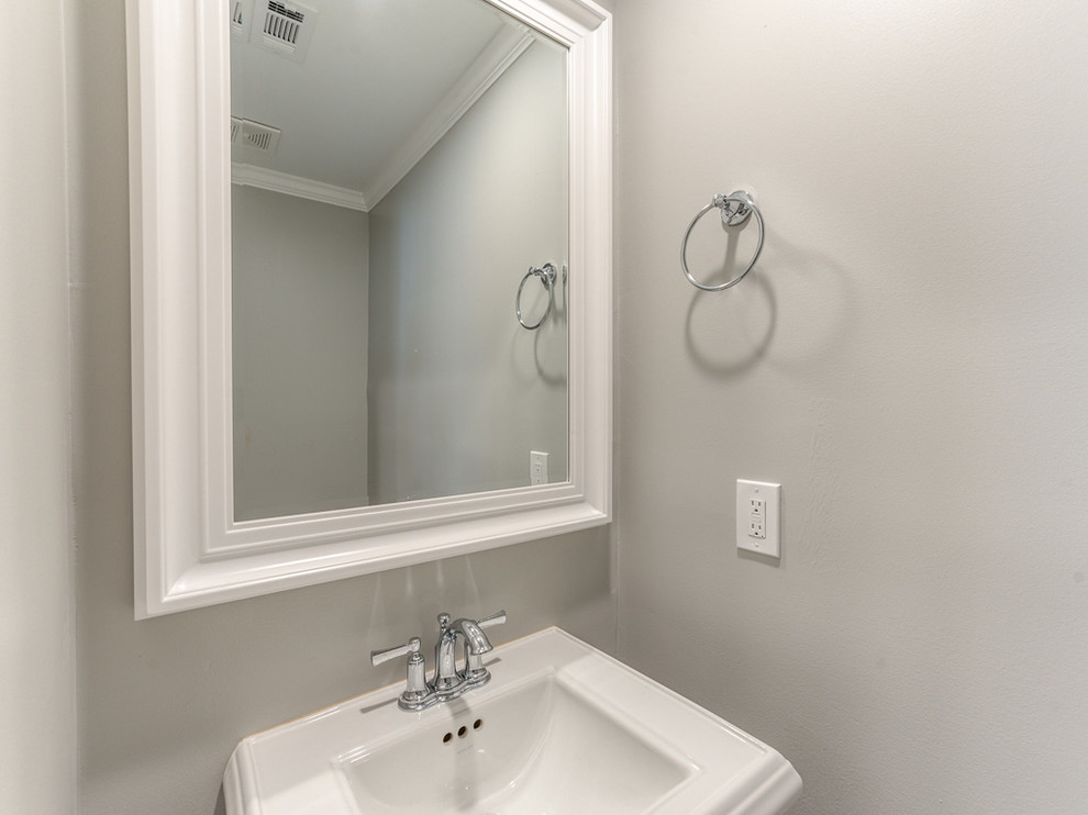 Immagine di un piccolo bagno di servizio classico con WC monopezzo, piastrelle grigie, piastrelle in gres porcellanato, pareti grigie, parquet scuro e lavabo a colonna