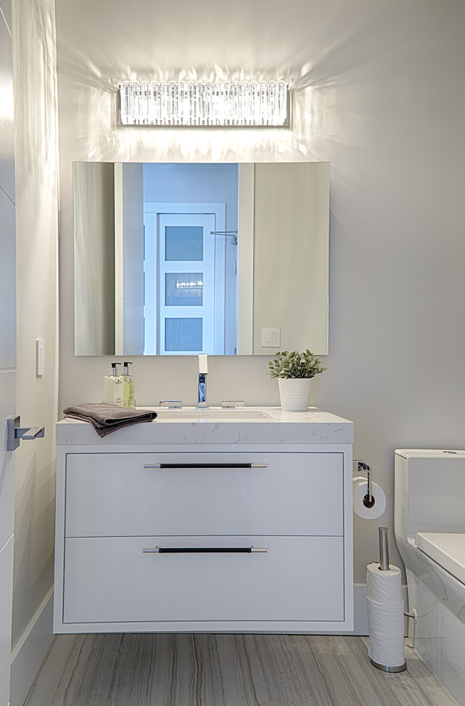 Idee per un piccolo bagno di servizio minimal con ante lisce, ante bianche, pareti grigie, top in quarzo composito e top bianco