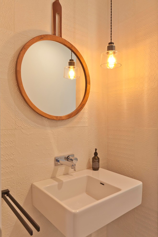 Esempio di un bagno di servizio design di medie dimensioni con piastrelle bianche, piastrelle in gres porcellanato, pareti bianche e lavabo sospeso