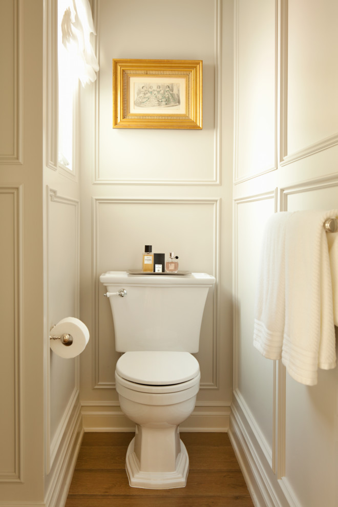 Small elegant medium tone wood floor powder room photo in Los Angeles with a two-piece toilet and white walls