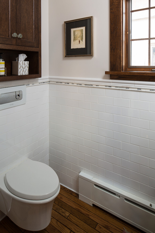 Réalisation d'un petit WC suspendu tradition en bois foncé avec un placard avec porte à panneau encastré, un carrelage blanc, un carrelage métro, un mur blanc, un sol en bois brun, un lavabo encastré et un plan de toilette en marbre.