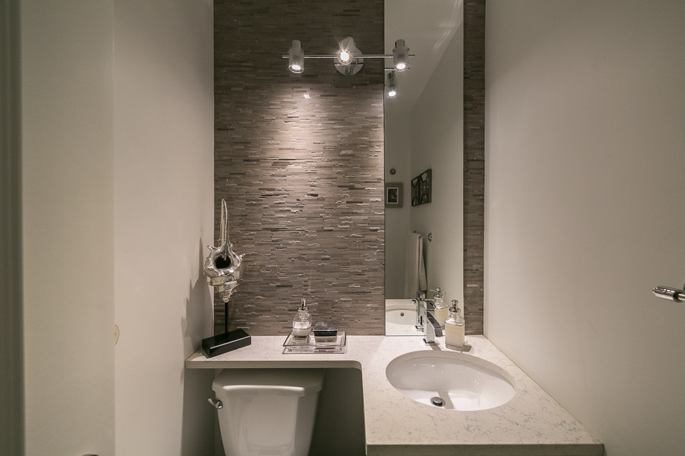 Ispirazione per un piccolo bagno di servizio minimalista con lavabo sottopiano, top in quarzo composito, piastrelle beige, pareti bianche, WC a due pezzi e piastrelle a listelli