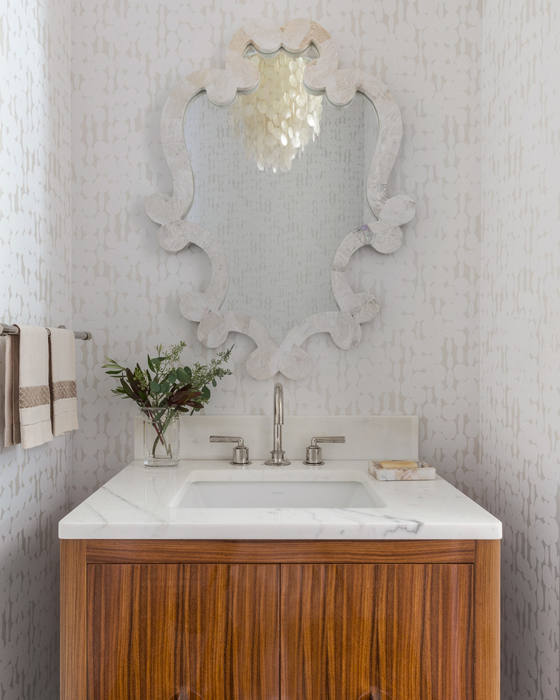 Klassische Gästetoilette mit flächenbündigen Schrankfronten, hellbraunen Holzschränken, weißer Wandfarbe, Unterbauwaschbecken und weißer Waschtischplatte in San Francisco