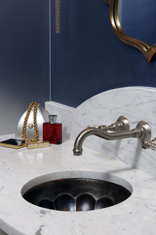 Immagine di un bagno di servizio mediterraneo con consolle stile comò, ante grigie, piastrelle bianche, piastrelle di marmo, pareti blu, pavimento in marmo, lavabo sottopiano, top in marmo, pavimento bianco e top bianco
