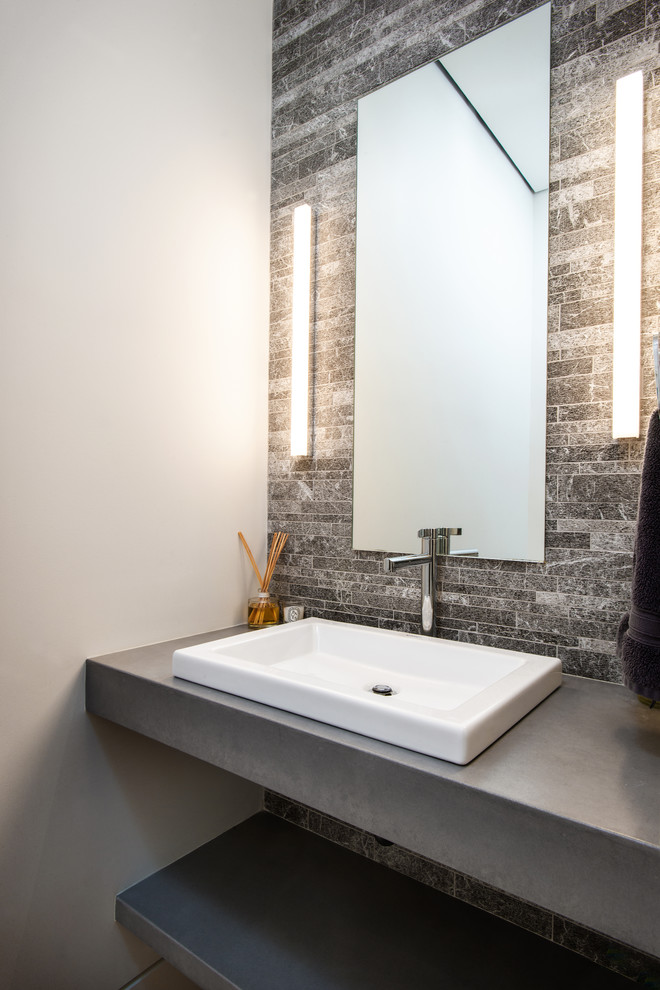 Idee per un bagno di servizio contemporaneo con piastrelle grigie, piastrelle in pietra, pareti grigie, lavabo da incasso, top in cemento e top grigio