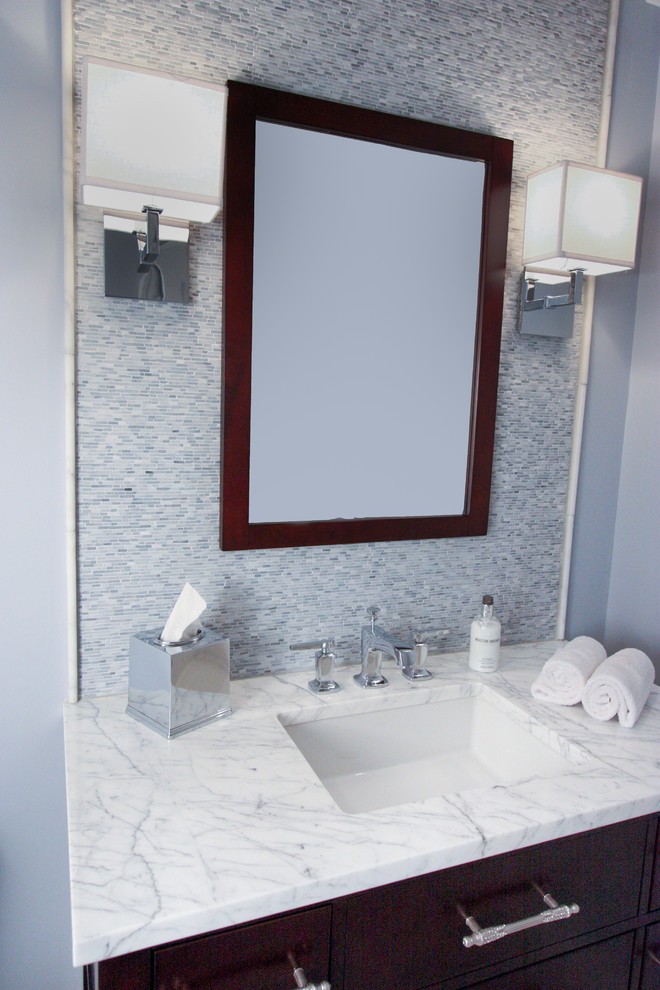 Example of a mid-sized transitional gray tile powder room design in New York with an undermount sink, marble countertops and a two-piece toilet