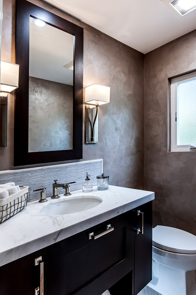 Inspiration for a mid-sized transitional white tile and matchstick tile marble floor powder room remodel in Los Angeles with shaker cabinets, dark wood cabinets, a two-piece toilet, beige walls, an undermount sink and marble countertops