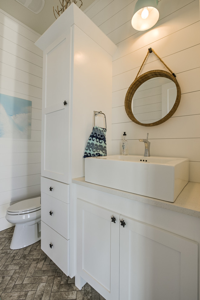 Powder room - coastal brick floor powder room idea in Omaha with shaker cabinets, white cabinets, a two-piece toilet, a vessel sink, quartz countertops and white countertops