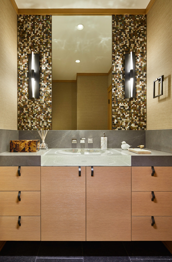 Inspiration for a transitional multicolored tile and mosaic tile terra-cotta tile, black floor and wallpaper powder room remodel in Seattle with flat-panel cabinets, light wood cabinets, beige walls, an integrated sink, gray countertops and a built-in vanity