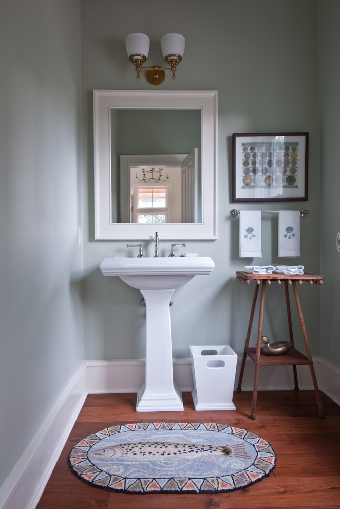 Cette image montre un petit WC et toilettes marin avec WC séparés, un mur vert et un sol en bois brun.