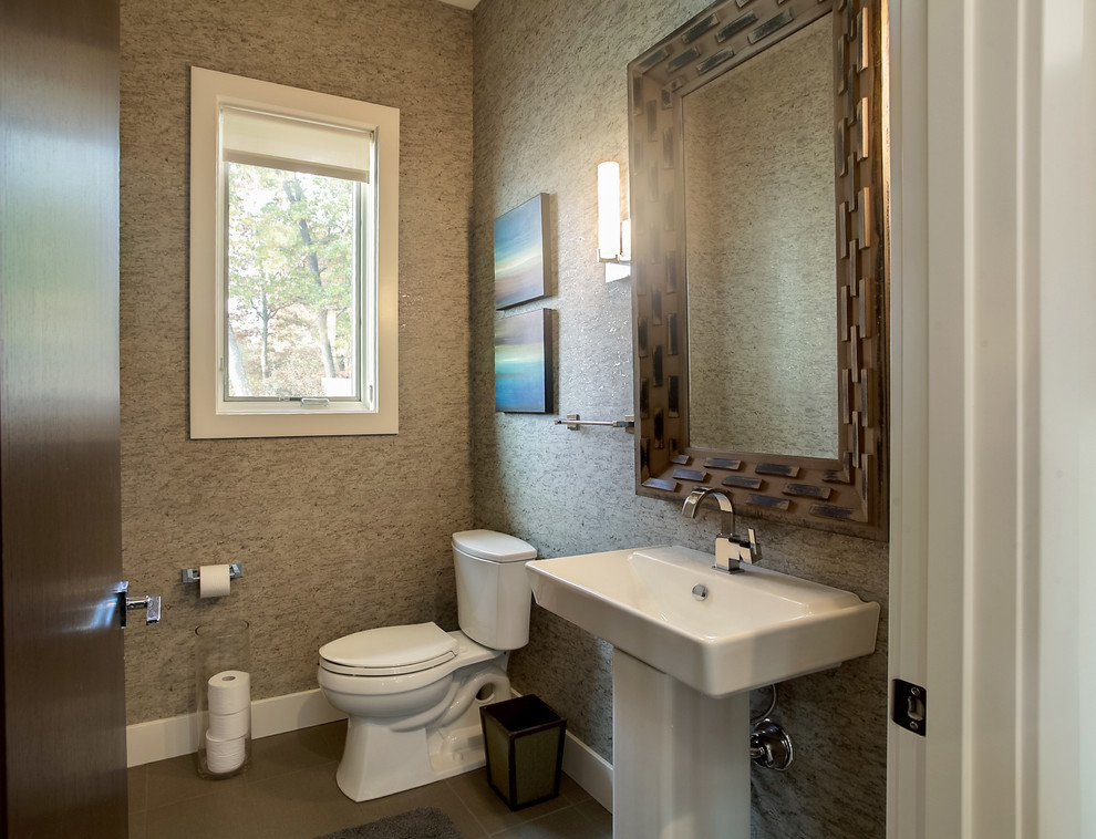 Inredning av ett klassiskt litet toalett, med en toalettstol med separat cisternkåpa, beige väggar, klinkergolv i porslin och ett piedestal handfat