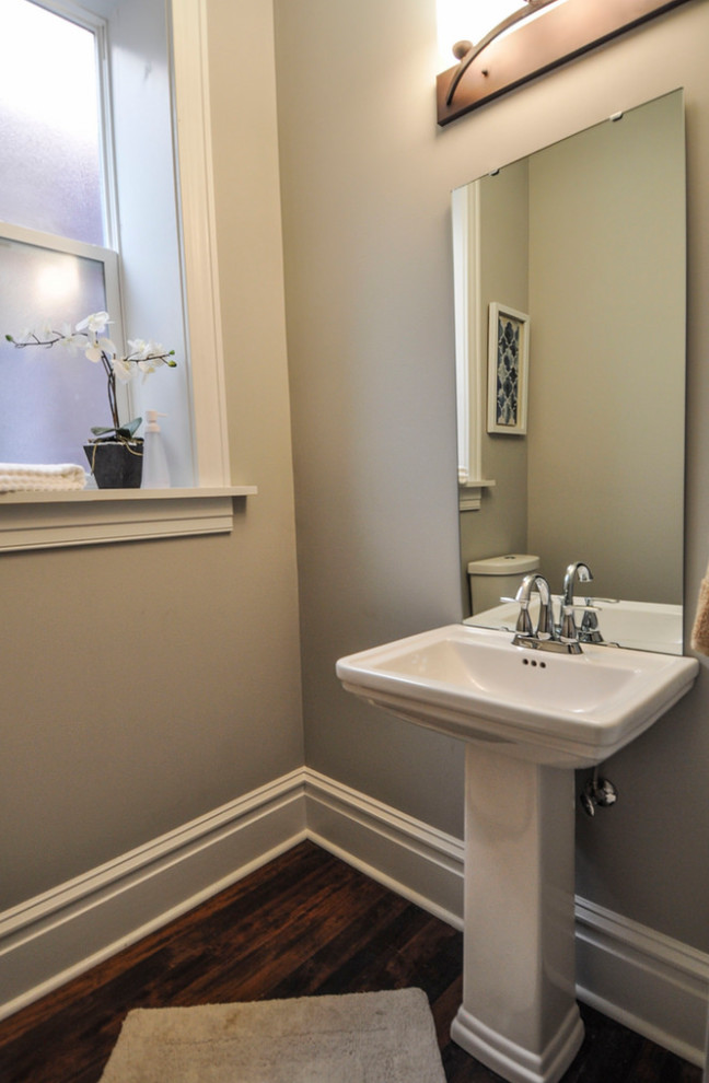 Foto di un piccolo bagno di servizio classico con pareti grigie, pavimento in legno massello medio e lavabo a colonna