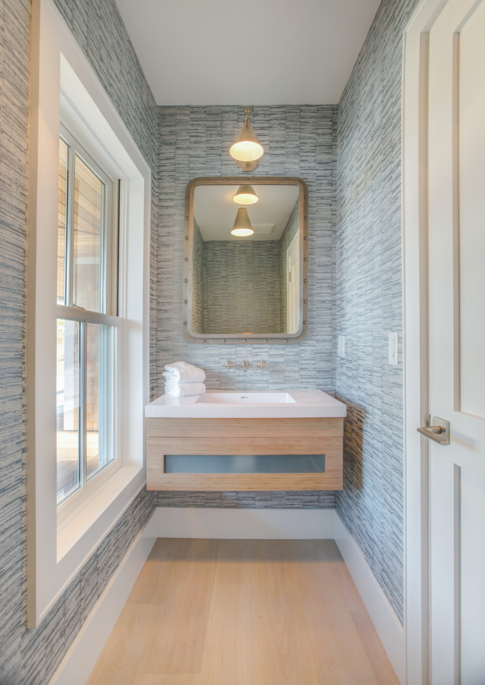 Photo of a coastal cloakroom in Other with flat-panel cabinets, light wood cabinets, grey walls, light hardwood flooring, a console sink, beige floors and white worktops.