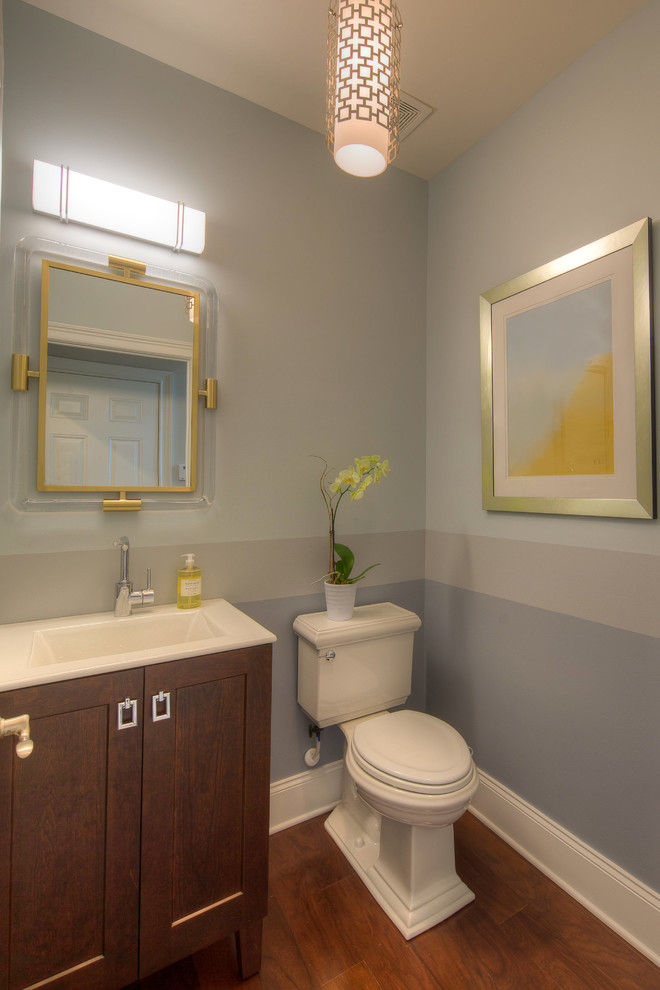 Réalisation d'un petit WC et toilettes vintage en bois foncé avec un placard à porte shaker, WC séparés, un mur multicolore, un sol en bois brun, un lavabo encastré et un sol marron.