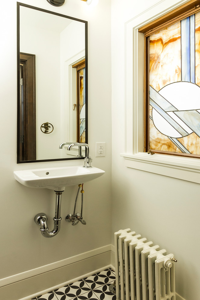 На фото: туалет в стиле неоклассика (современная классика) с унитазом-моноблоком, белыми стенами, полом из цементной плитки и подвесной раковиной с