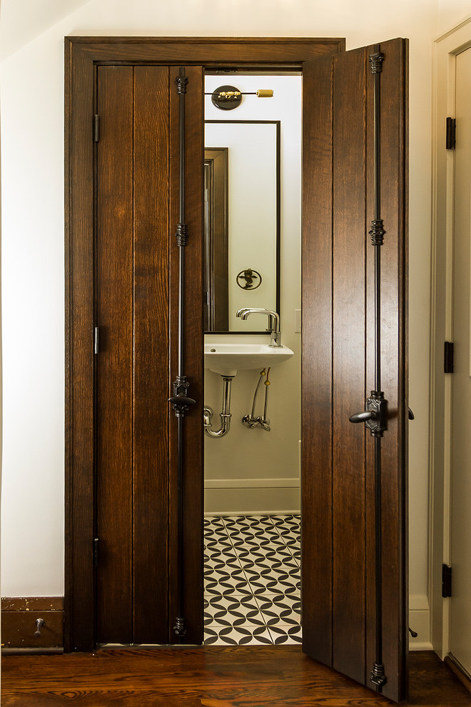 Imagen de aseo clásico renovado con sanitario de una pieza, paredes blancas, suelo de azulejos de cemento y lavabo suspendido