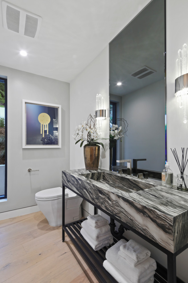Contemporary cloakroom in Los Angeles with grey walls, medium hardwood flooring, an integrated sink, brown floors, grey worktops and a freestanding vanity unit.