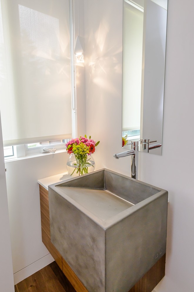 Idée de décoration pour un WC et toilettes minimaliste en bois brun avec un lavabo posé, un placard à porte plane, un plan de toilette en quartz, un mur blanc et un sol en bois brun.