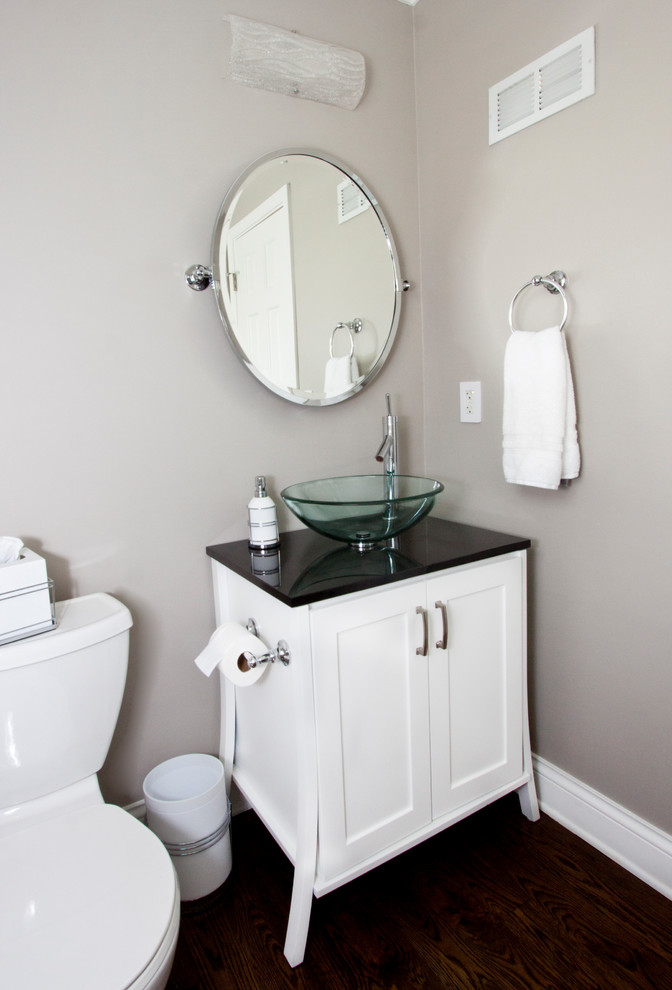 Photo of a medium sized classic cloakroom in Kansas City with shaker cabinets, white cabinets, a two-piece toilet, grey walls, dark hardwood flooring, a vessel sink, engineered stone worktops and brown floors.