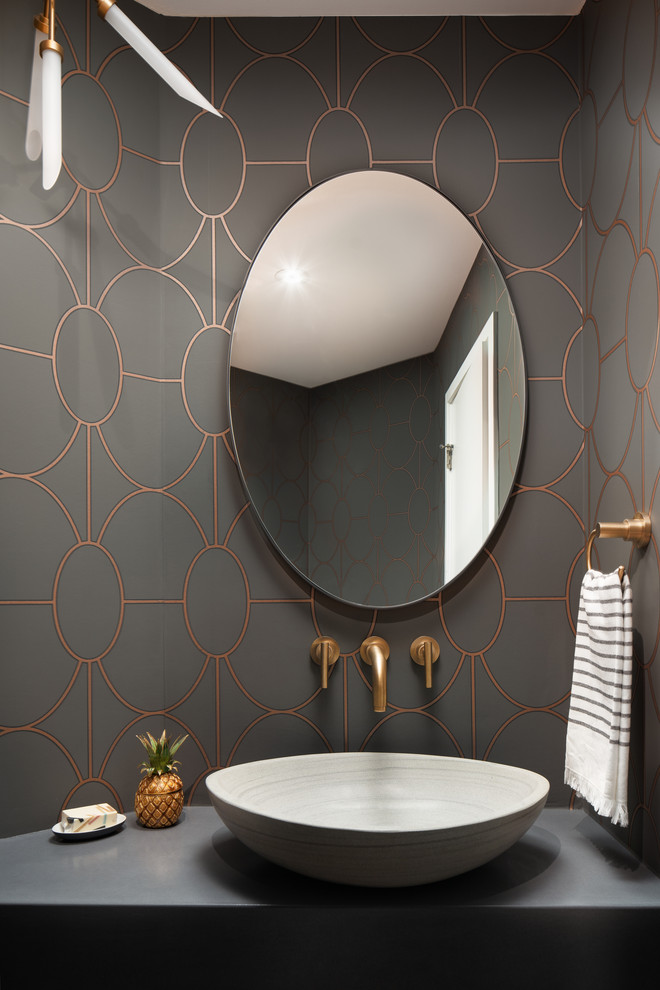 Diseño de aseo moderno con paredes grises, suelo de madera en tonos medios, lavabo sobreencimera, encimera de cemento, suelo marrón y encimeras grises