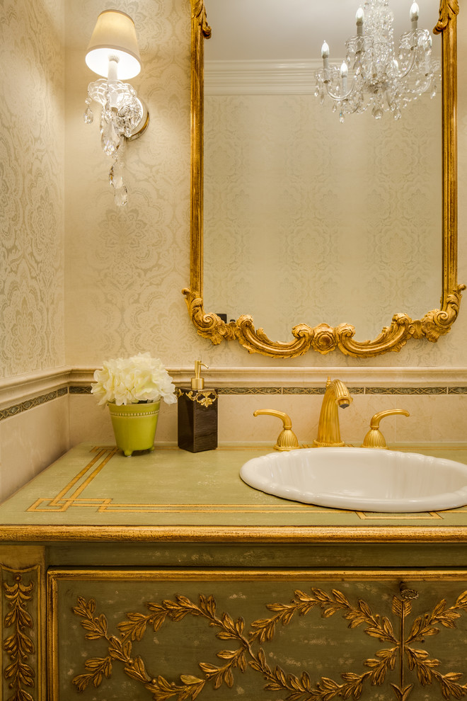 Foto di un bagno di servizio classico di medie dimensioni con lavabo da incasso, consolle stile comò, ante verdi, top in legno, piastrelle beige, piastrelle in pietra e pareti verdi