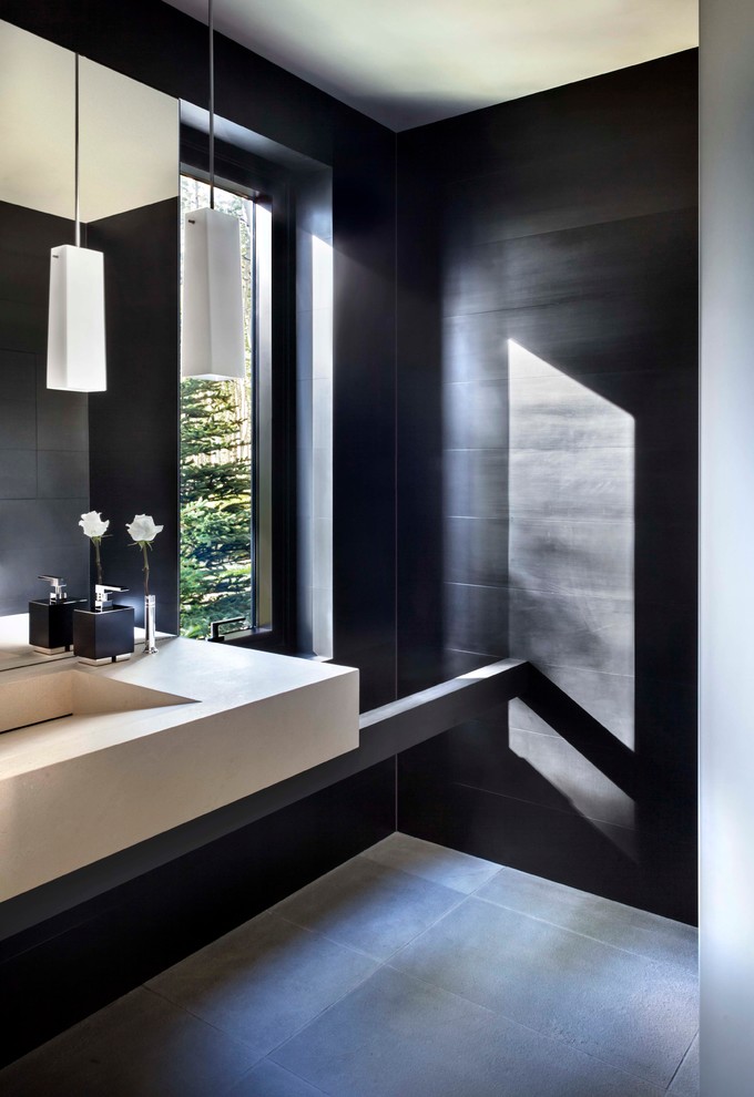デンバーにあるコンテンポラリースタイルのおしゃれなトイレ・洗面所 (一体型シンク、黒いタイル) の写真