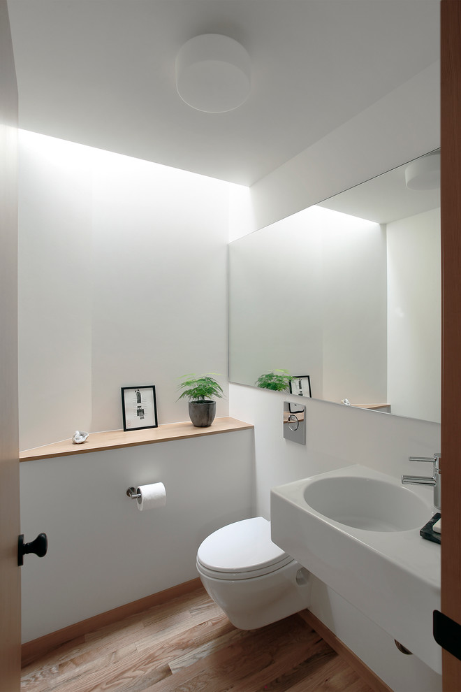 Ejemplo de aseo vintage pequeño con paredes blancas, suelo de madera clara y lavabo integrado