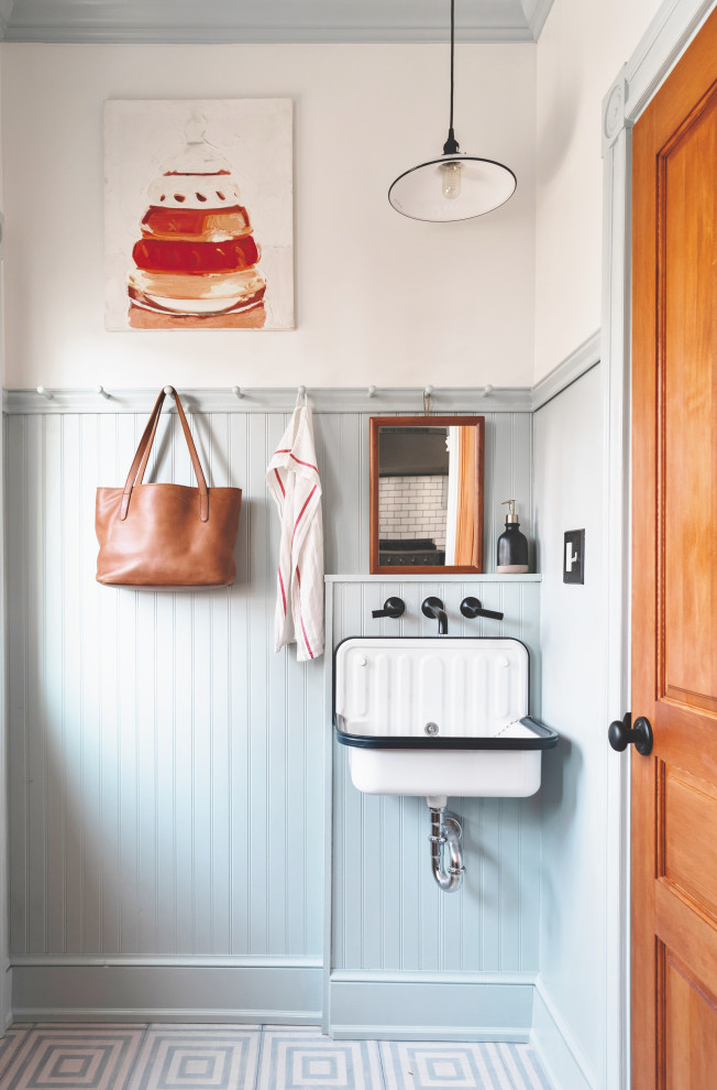 Cette image montre un WC et toilettes traditionnel avec carreaux de ciment au sol, un lavabo suspendu et un sol bleu.