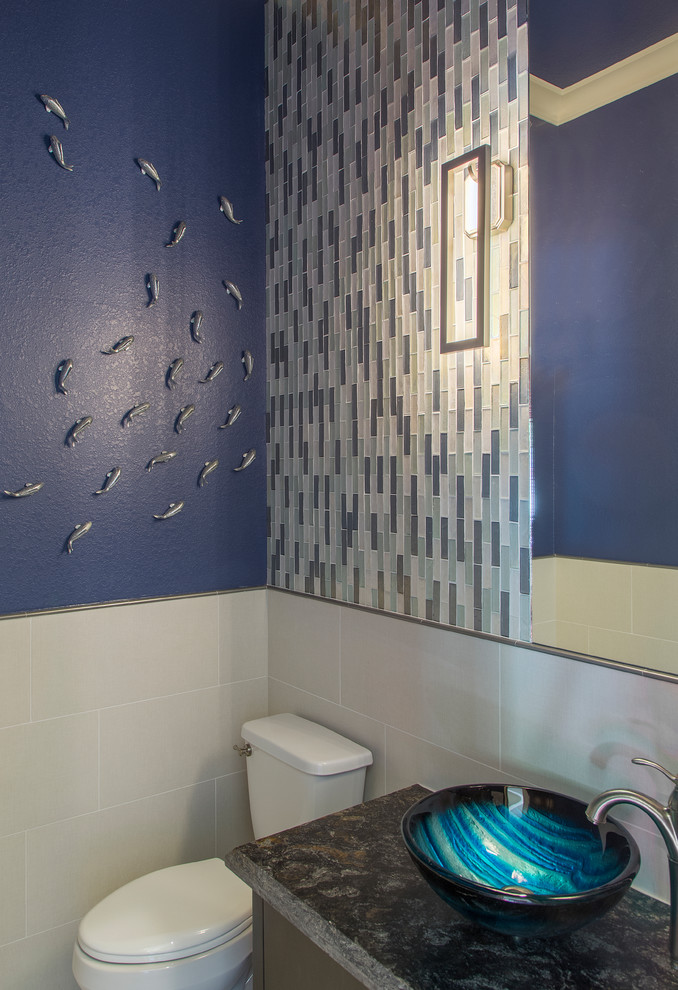 Diseño de aseo de pie contemporáneo pequeño con puertas de armario marrones, sanitario de una pieza, baldosas y/o azulejos azules, baldosas y/o azulejos en mosaico, paredes azules, lavabo sobreencimera, encimera de granito y encimeras negras
