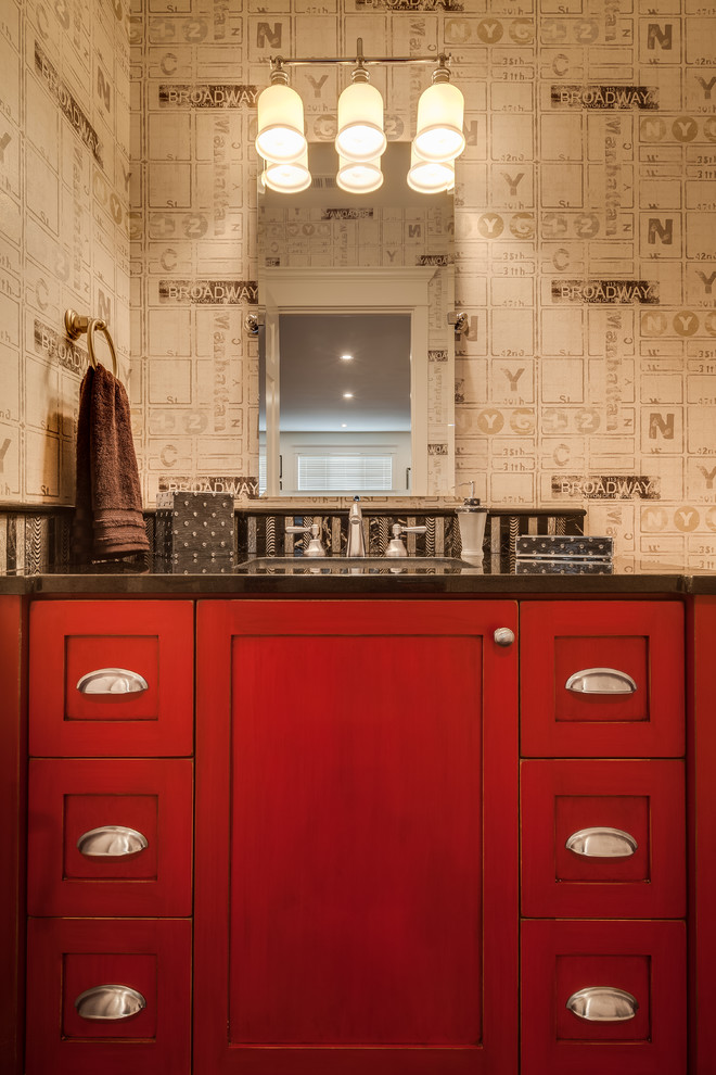 Aménagement d'un petit WC et toilettes classique avec un placard avec porte à panneau encastré, des portes de placard rouges, un carrelage noir, un mur multicolore, un lavabo encastré et un plan de toilette en granite.