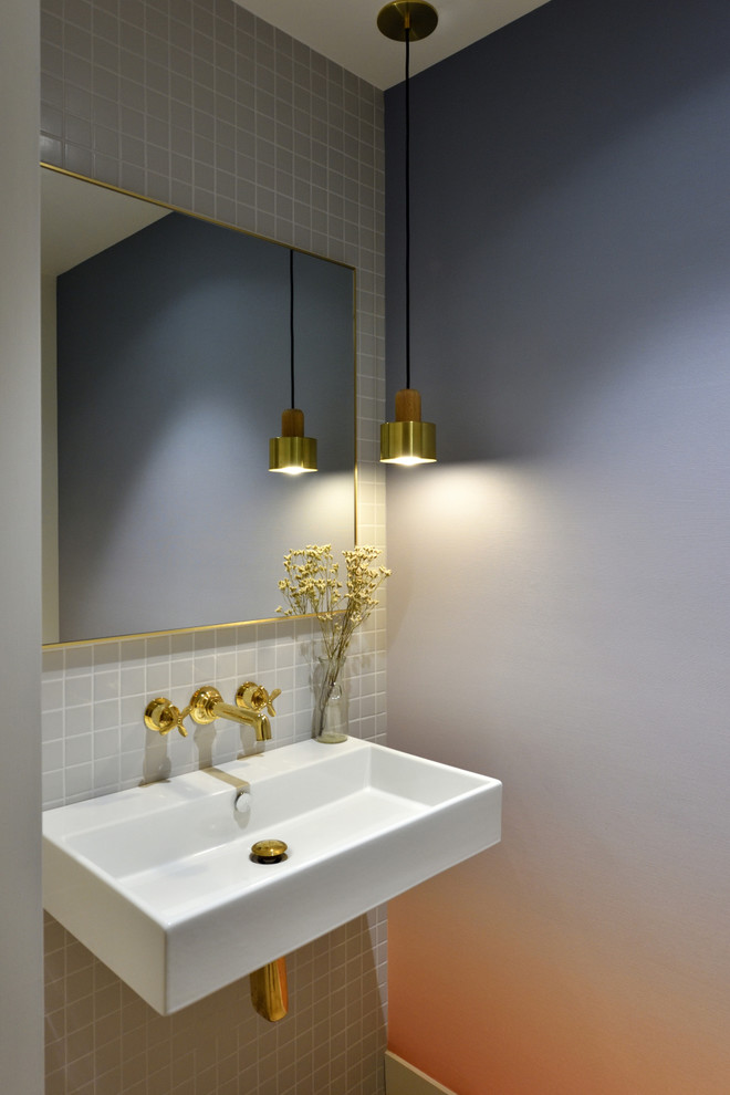 Idée de décoration pour un WC suspendu minimaliste de taille moyenne avec un carrelage gris, des carreaux de céramique, un mur gris, parquet clair, un lavabo suspendu, un plan de toilette en surface solide et un sol beige.