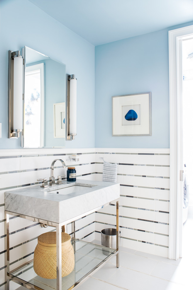 ニューヨークにある高級な中くらいなビーチスタイルのおしゃれなトイレ・洗面所 (オープンシェルフ、白いタイル、マルチカラーのタイル、磁器タイルの床、メタルタイル、青い壁、コンソール型シンク、マルチカラーの床) の写真